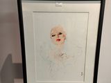 a drawing of a woman ' s face is shown in a black frame