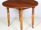 une photo d'une table en bois munie de roulettes posée sur un sol blanc