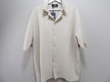 white shirt hanging on a hanger against a white wall