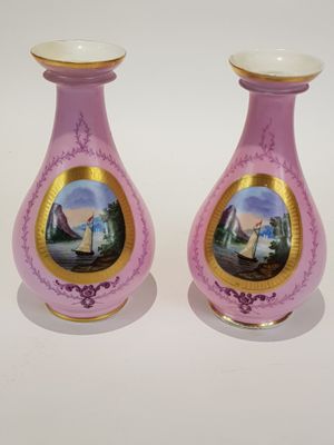 une paire de vases roses ornés d'une illustration représentant un bateau