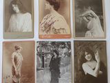 several old photos of women in formal dress are displayed on a table