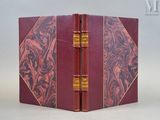 un gros plan sur un livre à la couverture rouge et aux bords dorés