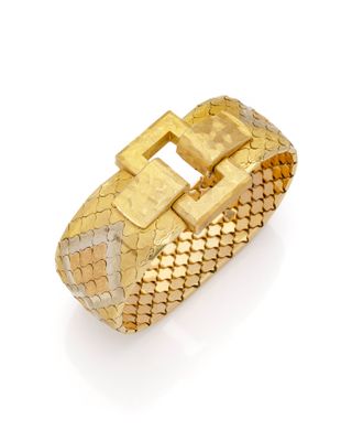 gros plan d'un bracelet en or sur fond blanc