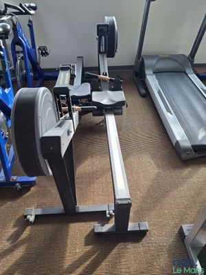 une photo d'une salle de sport équipée d'un tapis de course, d'un vélo d'appartement et d'autres appareils