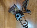 an old camera on the floor with a strap around it