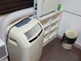 un climatiseur blanc placé à côté d'une fenêtre dans une pièce