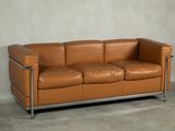 a brown leather couch sitting on a concrete floor