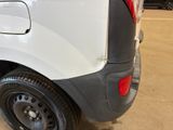 the rear end of a white van with black rims parked in a garage