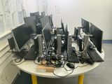 a lot of computers on a table in a room