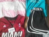 plusieurs t-shirts et shorts disposés dans une boîte posée sur une table