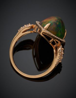 un gros plan d'une bague sertie d'un oplite noir et de diamants