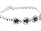 a close up of a bracelet with blue stones on a white background