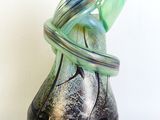 a glass vase with a ring around it on a white surface