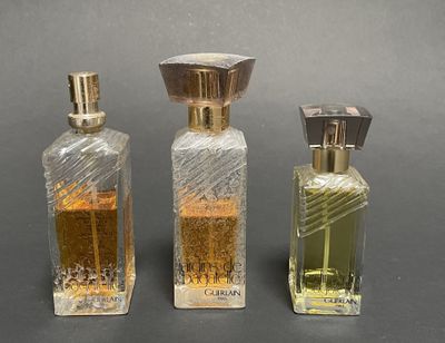 three bottles of perfume sitting next to each other on a table