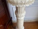 un socle en marbre blanc surmonté d'une horloge
