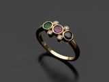gros plan d'une bague en or avec trois pierres de couleurs différentes