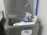 un évier dans lequel se trouve une bouteille d'eau