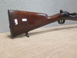 an old rifle with a wooden barrel on a table