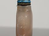 a small glass jar with a lid on a table