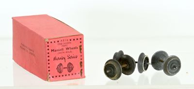 une boîte rose et deux boutons noirs sur une surface blanche