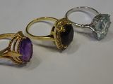 three rings with different colored stones sitting on top of each other
