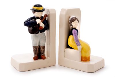 two figurines of a man and a woman sitting on a bench