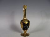 a gold vase with a black and white design on it