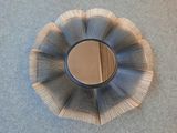 un miroir argenté en forme de fleur sur un fond bleu