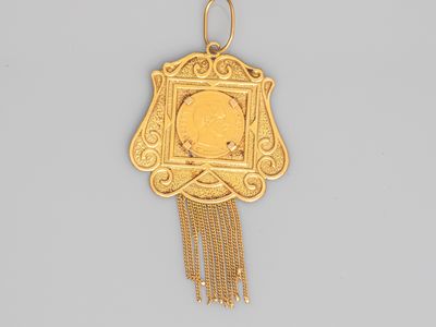 an image of a gold pendant with a picture of a woman