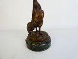 statue en bronze représentant une femme et un chien, posée sur un socle en marbre