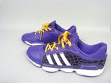 des chaussures violettes et blanches avec des lacets jaunes, posées sur une surface blanche