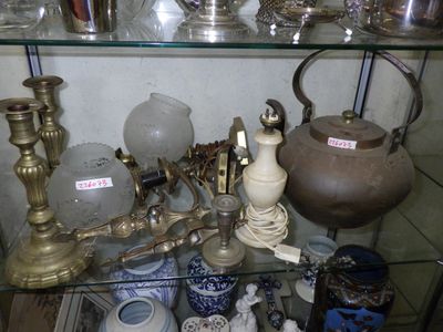 a glass shelf filled with various antique items on display