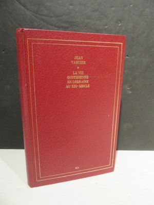 un vieux livre rouge posé sur une table près d'un mur noir
