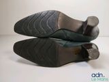 pair of black leather shoes on white surface with white background