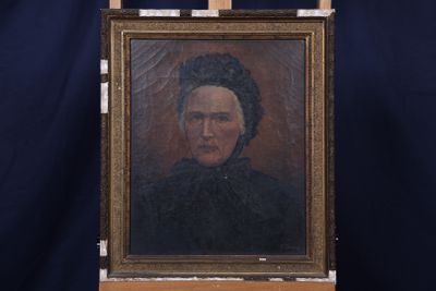 Une peinture à l'huile représentant une femme en robe noire est posée sur un chevalet.