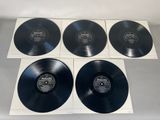 four black vinyl records on a white surface