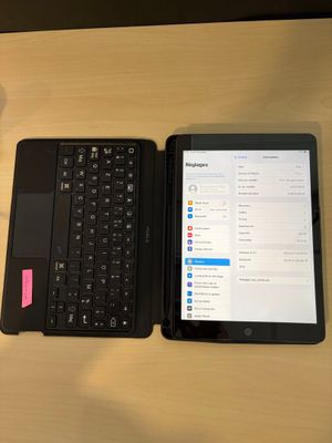 un ordinateur portable et une tablette posés sur une table, à côté d'une tasse de café