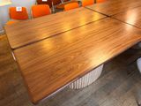 a large wooden table with orange chairs in a room