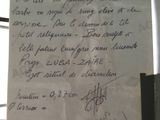 a piece of paper with writing on it that is attached to a pole