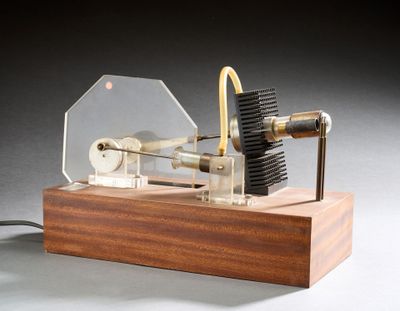 une petite maquette de machine à vapeur posée sur un socle en bois