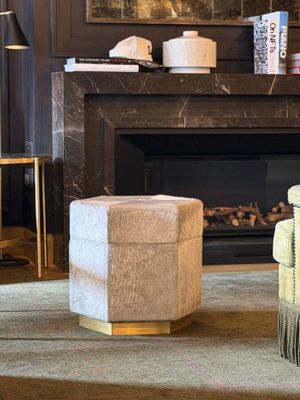 a chair and ottoman in front of a fireplace in a living room