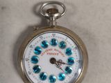 a silver pocket watch with blue flowers on it