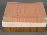 three books are stacked on top of each other on a table