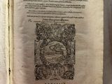 un vieux livre posé sur une table à côté d'une tasse