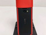 the back of a red and black cell phone sitting on top of a stand