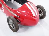 a red toy car that is sitting on a white surface