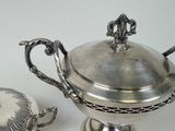 a silver plate with a silver lid and a silver cup
