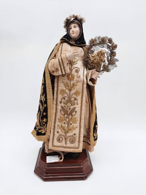 une statue représentant une femme tenant un bouquet de fleurs, posée sur un socle en bois