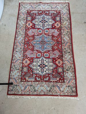 un tapis oriental posé au sol, à côté de toilettes blanches
