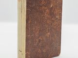 an old book sitting on top of a white surface